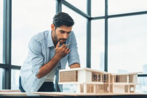 Smart civil architect engineer looking while planing design house construction with blueprint, house model and architectural equipment. Designer measuring and inspecting house model. Design. Tracery. SSUCv3H4sIAAAAAAAACpySTW7DIBCF95V6B4t1kLDB2O5Vqi6GH8coBCKMU1VR7l6M7Yhuu2O+Gd68GXi8v1UVEjAbiT6qxxql2Fi7zDFANN4lTE47D9opHUpyD5STEoApI61M9MGALaGAKCcHV52gW6xd8TMn0RwhLrOeVy87khD1OWls8CWxGf7c4upI5GS6kVIInQo2LyKzA23i/7q5Hb5eA5+1kz/ZcDFI0FbDNsjuEUnaNf1YM6yBCsyEBjxwMmDSSyKBjw2v9dEZMdWQZoAW97JLxUx0qbiXmMmxGxkfNXDIljYf6PIddbiWe4NFGV+s7O4l2LWAFjbB3CDAn3u3YKRx54L4OOVHP5SkX1wM68ivTSHr/Q2EXZ90TG30wSeY51SuDl70lumL+WvRx/mYF7arIpVefg1rShkjhAw96+uaU8r3gu23TCbpZDuHUIrlxahyKrM6QBR4Q5gYsWiBpV2KAQ8KKK6boW2GfoSW8bTV5y8AAAD//wMAYgx5xhYDAAA=